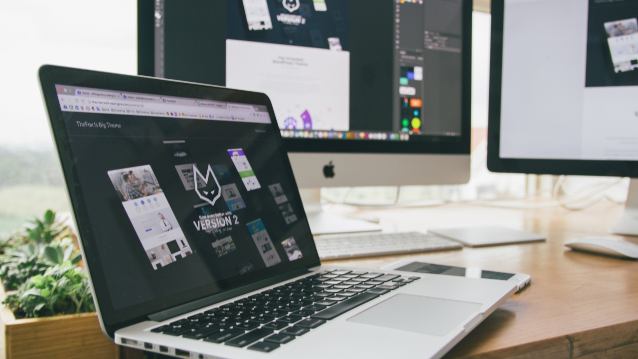 Laptop i monitori prikazuju dizajn projekte na radnom stolu u kućnom okruženju